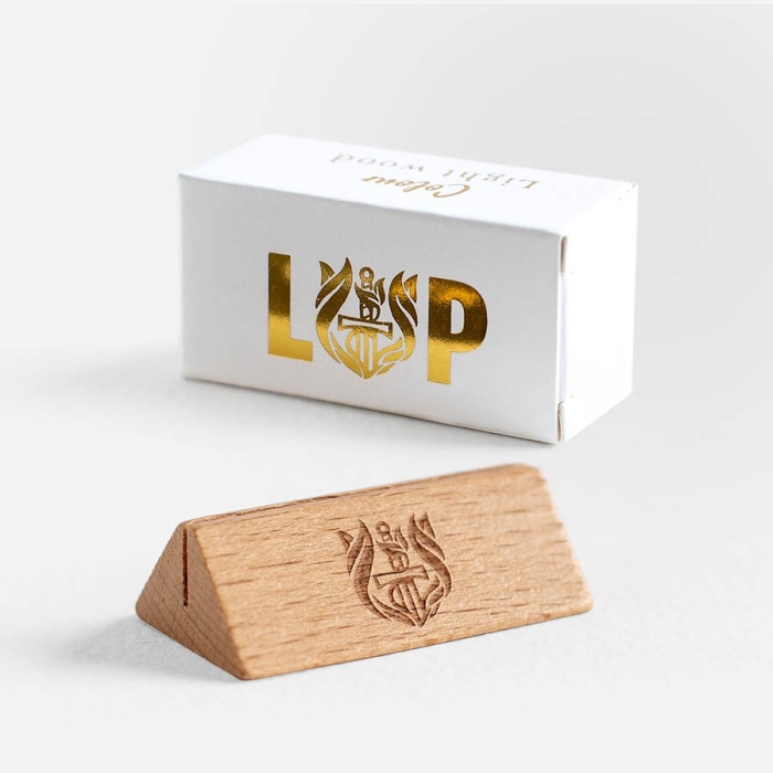 Magnetic wooden card stand embossed with our L&P logo and displayed next to its white box with gold foil
